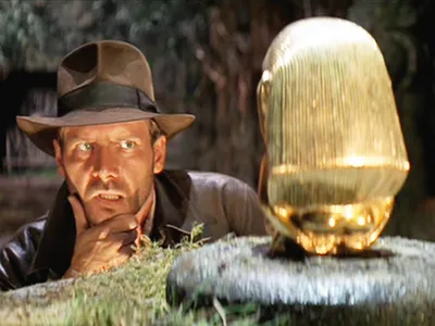 Harrison Ford as Indiana Jones, sizing up the idol, in the opening scene of Raiders of the Lost Ark