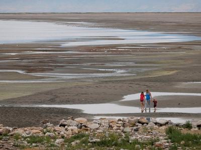 Park visitors walk along a section of the Great Salt Lake that used to be underwater at the Great Salt Lake State Park near Magna, Utah.&nbsp;