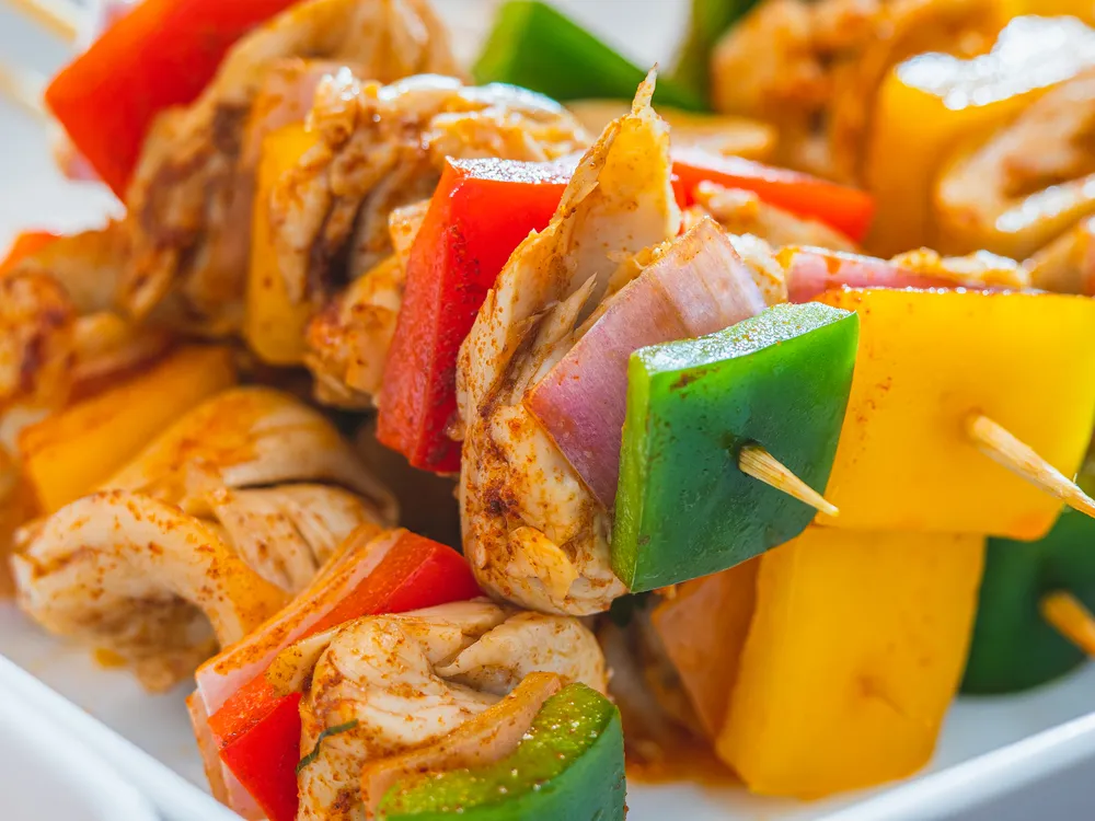 skewers with lab-grown chicken, peppers and onions on a plate