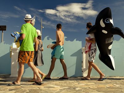 Focused on the waves, whether real or decorative, a flip-flop-wearing family&mdash;and their orca inflatable&mdash;heads to the beach.